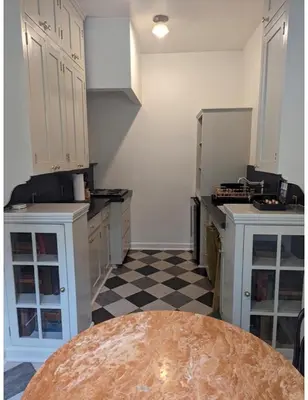 a kitchen with white cabinets and a checkered floor at Villa Carlotta - 30 Day Requirement in Los Angeles
