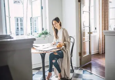 a woman sitting at a table with a pastry at Villa Carlotta - 30 Day Requirement in Los Angeles