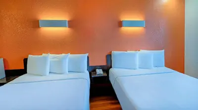 two beds in a room with lights on the wall at Suites Los Angeles CA Los Angeles LAX in Inglewood