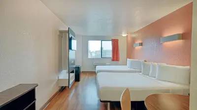 a room with a large white bed and a table at Suites Los Angeles CA Los Angeles LAX in Inglewood