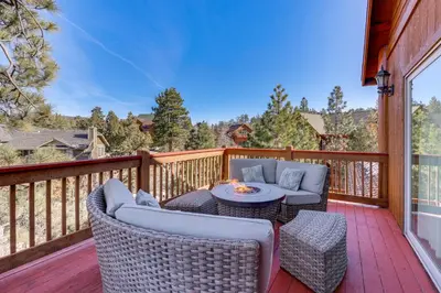 a deck with two chairs and a table on a balcony at Elegant Big Bear Cabin Half Mi to Big Bear Lake! in Big Bear Lake