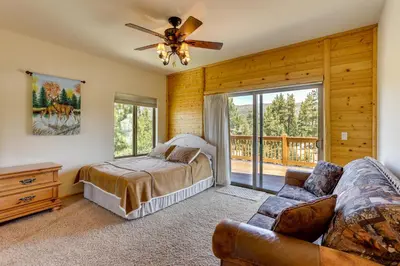 a bedroom with a bed and a couch at Elegant Big Bear Cabin Half Mi to Big Bear Lake! in Big Bear Lake