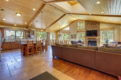 a large living room with a large couch and a kitchen at Elegant Big Bear Cabin Half Mi to Big Bear Lake! in Big Bear Lake