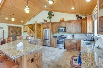 a large kitchen with wooden cabinets and granite counter tops at Elegant Big Bear Cabin Half Mi to Big Bear Lake! in Big Bear Lake
