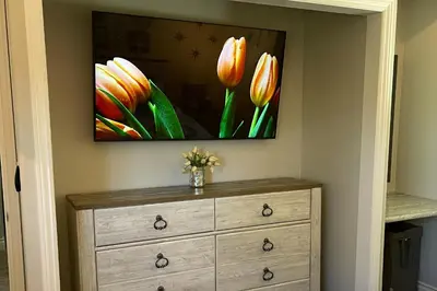 a painting of tulips on a wall above a dresser at Surreal Feel Lakeview Chalet in Lake Arrowhead
