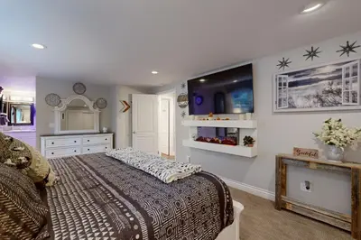 a bedroom with a large bed and a dresser at Surreal Feel Lakeview Chalet in Lake Arrowhead