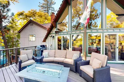 a screened in porch with chairs and a coffee table at Surreal Feel Lakeview Chalet in Lake Arrowhead