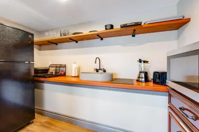 a kitchen with a counter with a sink and a refrigerator at Surreal Feel Lakeview Chalet in Lake Arrowhead