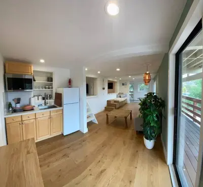 a kitchen and living room with a white refrigerator at Apartment with Private Deck & Mountain Views in Topanga