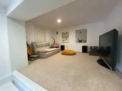 a living room with a couch and a flat screen tv at Apartment with Private Deck & Mountain Views in Topanga