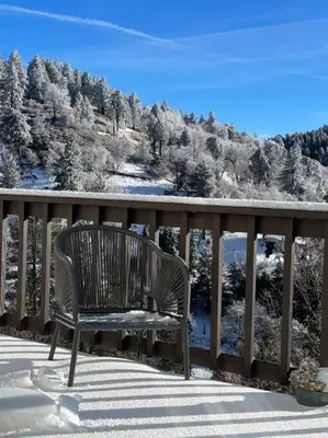 a bench sitting on a balcony with a snow covered mountain at @wild_olive_den ~ Serene Weekend Getaway Cabin in Running Springs