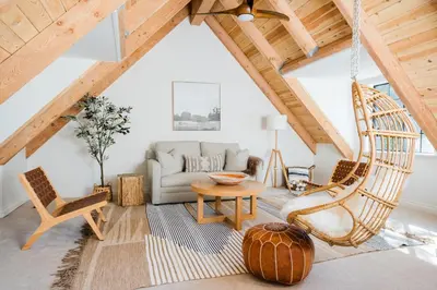 a living room with a hammock in the attic at Wild Olive Lodge ° Serene grandma chíc getaway cabin in Running Springs