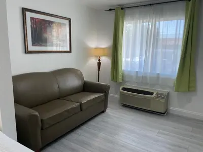 a living room with a couch and a window at Loma Linda Inn in San Bernardino