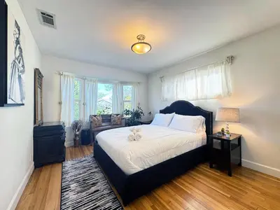 a bedroom with a large bed with a black headboard at Charming 3BR House - Hal-UC in Los Angeles
