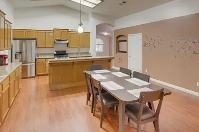 a large kitchen with a wooden table and chairs at Pet-Friendly California Retreat with Fenced-In Yard! in Bakersfield