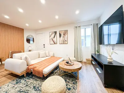 a living room with a white couch and a flat screen tv at Hollywood Habitat - BR11-WH in Los Angeles
