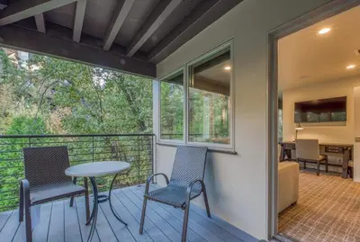 a balcony with a table and chairs and a bedroom at Lake Front Modern Luxury in Lake Arrowhead