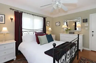 a bedroom with a black and white bed and a mirror at Charming Pasadena English Cottage on Tree Lined Street in Pasadena