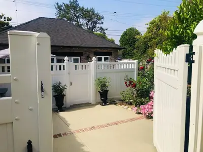 a white fence with potted plants in a yard at Charming Pasadena English Cottage on Tree Lined Street in Pasadena