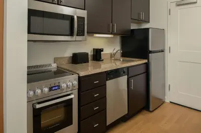 a small kitchen with a stove and a refrigerator at TownePlace Suites by Marriott Lancaster in Lancaster