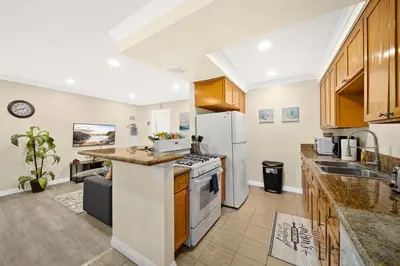 a kitchen with wooden cabinets and a white refrigerator at Cozy & Serene ~ 12mins to Downtown LA in Alhambra