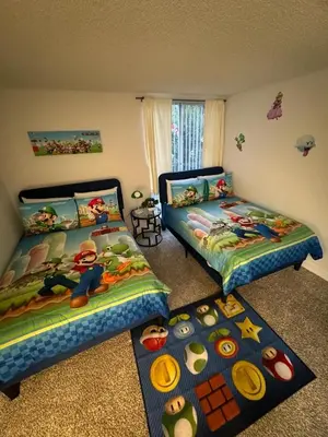 a bedroom with two beds and two rugs at Mario, Disney & not themed Loft Universal Studios 10min loft apartment in Los Angeles