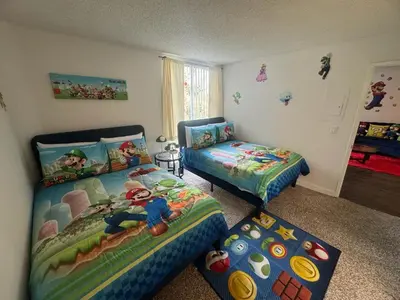 a bedroom with two twin beds and a window at Mario, Disney & not themed Loft Universal Studios 10min loft apartment in Los Angeles
