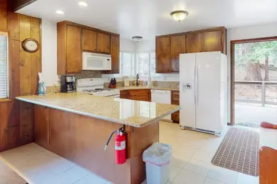 a kitchen with wooden cabinets and a white refrigerator at Rocky Pines in Twin Peaks