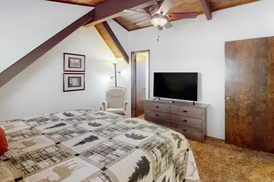 a bedroom with a bed and a flat screen tv at Rocky Pines in Twin Peaks