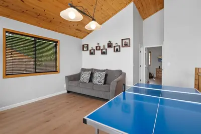 a living room with a blue ping pong table at 3 Cubs Lakefront - Stunning lakeside home with Hot Tub, Foosball, and Lake View in Big Bear Lake