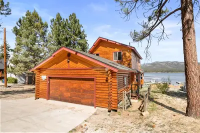 a log cabin with a garage at 3 Cubs Lakefront - Stunning lakeside home with Hot Tub, Foosball, and Lake View in Big Bear Lake