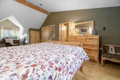 a bedroom with a large bed and a dresser at Abe's Cool Cabin - Nice luxury home with a game room, hot tub, and pool table in Big Bear Lake
