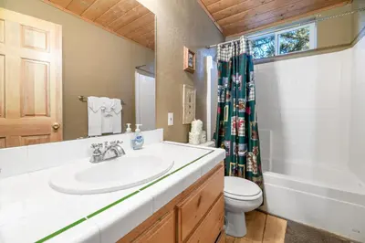 a bathroom with a sink and a toilet and a tub at Abe's Cool Cabin - Nice luxury home with a game room, hot tub, and pool table in Big Bear Lake