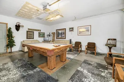 a living room with a pool table and chairs at Abe's Cool Cabin - Nice luxury home with a game room, hot tub, and pool table in Big Bear Lake