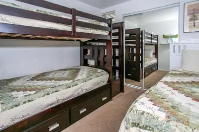 a bedroom with two bunk beds and a mirror at Bayview Condo - Condo is cozy and a great location for kayaking and paddle boarding! in Big Bear Lake