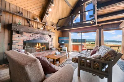 a living room with a fireplace and a couch at Alpine Lakefront - Lakefront cabin and all the amenities really fun from the pool table and spa in Big Bear Lake