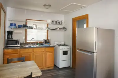 a kitchen with a white refrigerator and a table at Baby Bear - A delightful studio style property in the perfect central location! in Big Bear Lake