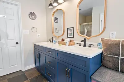 a bathroom with a blue and white sink and a mirror at BB Lake View Lodge - Gorgeous Lakeviews, Hot Tub, Jetted Tub, and Firepit! in Big Bear Lake