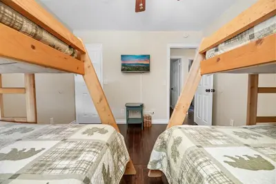 a bedroom with two bunk beds and a tv at BB Lake View Lodge - Gorgeous Lakeviews, Hot Tub, Jetted Tub, and Firepit! in Big Bear Lake