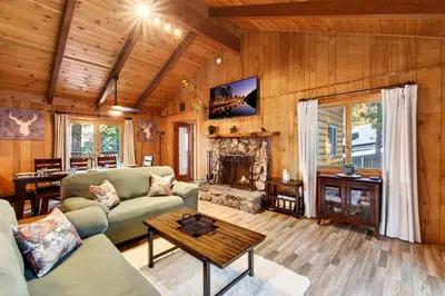 a living room with a couch and a fireplace at Bear Claw Cabin - Perfect location with an amazing game room and hot tub! in Big Bear Lake