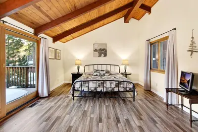 a bedroom with a bed and a large window at Bear Claw Cabin - Perfect location with an amazing game room and hot tub! in Big Bear Lake