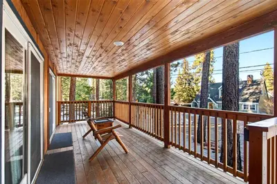 a large wooden deck with a bench on it at Bear Claw Cabin - Perfect location with an amazing game room and hot tub! in Big Bear Lake