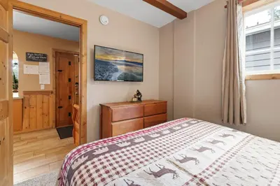 a bedroom with a bed and a dresser and a window at Bear Family Cabin - Stay together & play together! Foosball, billiards, hot tub, walk to lake! in Big Bear Lake