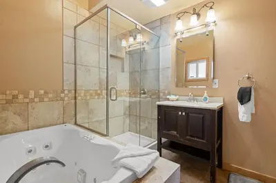 a bathroom with a tub and a sink and a shower at Bear Family Cabin - Stay together & play together! Foosball, billiards, hot tub, walk to lake! in Big Bear Lake