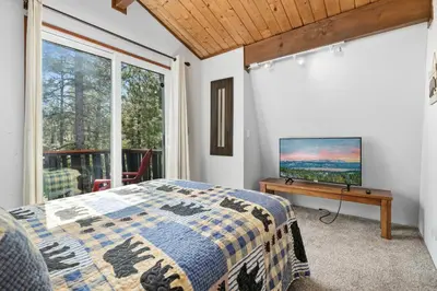 a bedroom with a bed and a flat screen tv at Bear PAC Hideout - Walk to Alpine Slide and only minuetes to The Village! Billiards and foosball! in Big Bear Lake