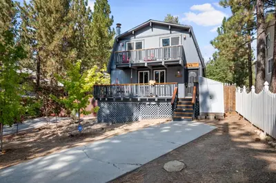 a house with a balcony and a fence at Bear PAC Hideout - Walk to Alpine Slide and only minuetes to The Village! Billiards and foosball! in Big Bear Lake