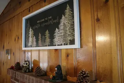 a picture hanging on a wall with christmas trees at Bear Paw Cabin - Cozy and quaint, the perfect mountain getaway! in Big Bear Lake