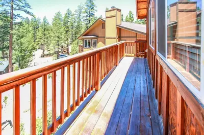 a wooden deck on a house with trees at Ben's Cool Cabin - Phenomenal views and an ideal location close to all the local attractions! in Big Bear Lake