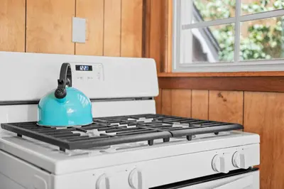 a blue tea kettle sitting on top of a stove at Big Bear Bungalow - Modern aesthetics meet mountain charm in this newly remodeled two-story home in Big Bear Lake