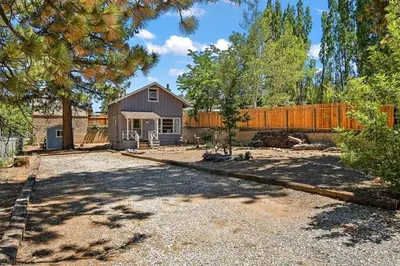 a large yard with a house and a fence at Big Bear Bungalow - Modern aesthetics meet mountain charm in this newly remodeled two-story home in Big Bear Lake
